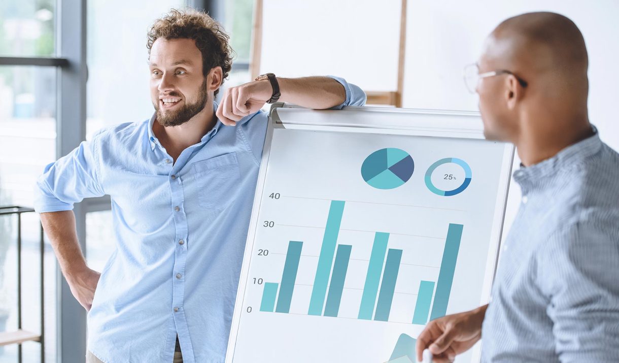 multiethnic-businessmen-standing-near-white-board--74GV65M